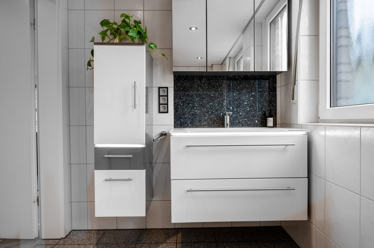 Fully furnished ground floor apartment with 2 rooms, light-filled living/dining area, separate kitchen, large terrace, lawn, and garage in a well-maintained 3-family house.